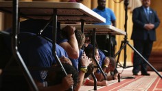 Volunteers participate in an earthquake drill during an event on earthquake preparedness.