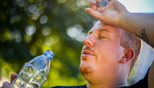 A man drinking water due to extreme heat