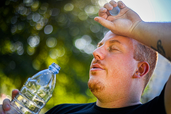 A man drinking water due to extreme heat