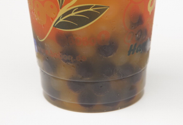 Balls of tapioca lie at the bottom of a cup of mango-flavoured bubble tea
