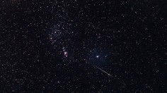 Meteor streaking through the night sky during the Geminid meteor shower 