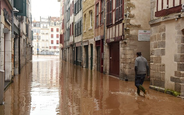 A pedestrian walking in flooded streets of Bayonne, southwestern France