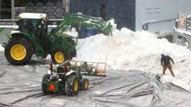 Field staff work on clearing the snow at Lumen Field 