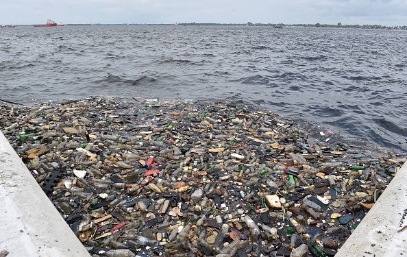 Plastic bottles and other waste floating in water 