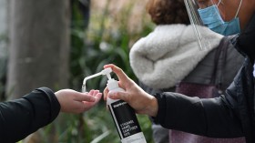 A health worker offers hand sanitiser outside a Covid-19 vaccination centre 