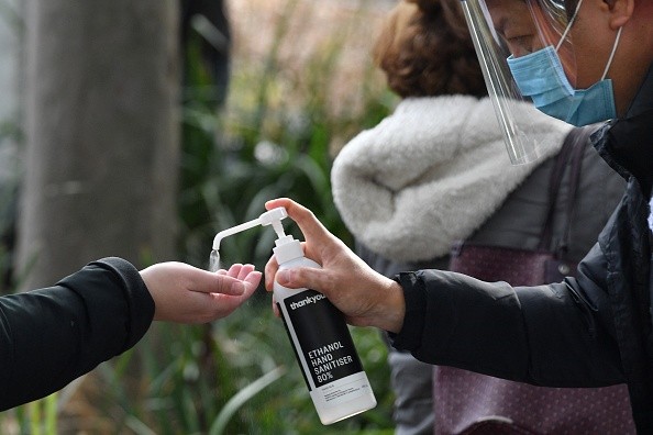 A health worker offers hand sanitiser outside a Covid-19 vaccination centre 