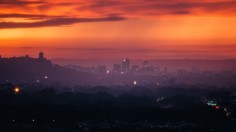 Red and purple sunset over hazy city