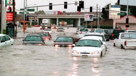 Motorists try to cross flood waters at the interse