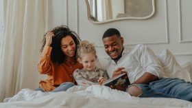 A Family Reading a Book on the Bed