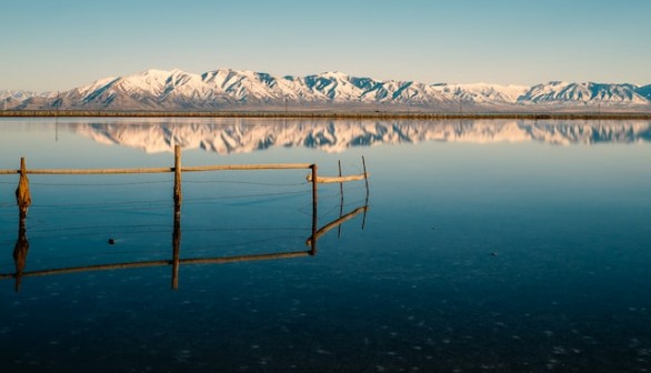 Blue lake with snowy mountain reflection.