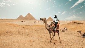 Tourist riding camel while exploring desert