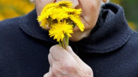 elderly woman smelling flowers