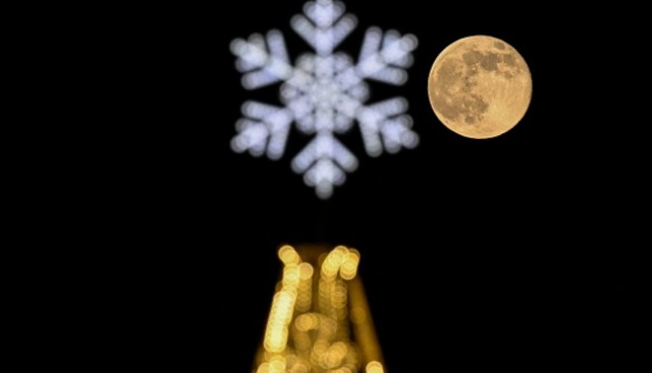 Wolf moon behind a Christmas and New Year's decoration in Moscow on January 7, 2023