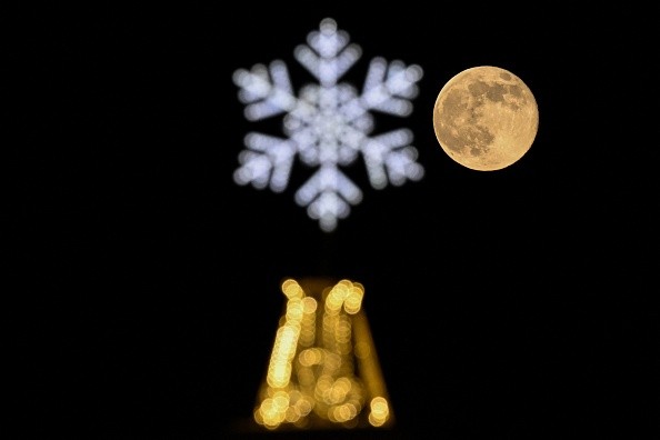 Wolf moon behind a Christmas and New Year's decoration in Moscow on January 7, 2023