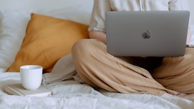 Anonymous woman using laptop in bedroom