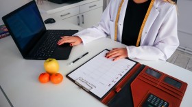 A Woman in White Coat Sitting at the Table