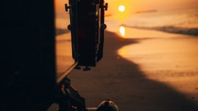 person holding camera during sunset 