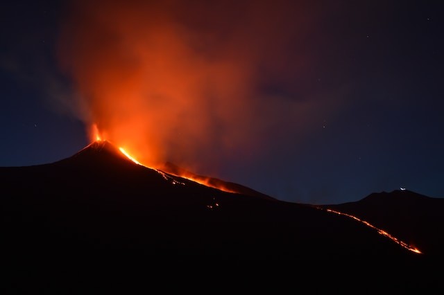 Black Mountain with flowing lava at nightime