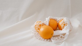 Four Orange Fruits In A Basket on White Linen