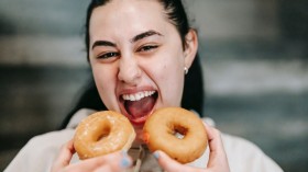 Hungry woman with delicious donuts at home