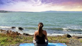 woman meditating at beach