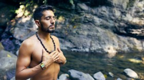 Man meditating near water