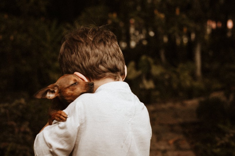 Boy Hugging Baby Dog