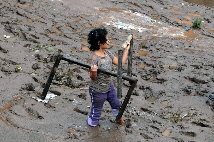 A girl recovers objects from the mud out