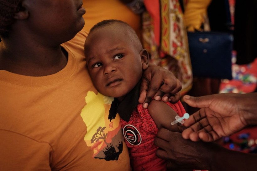 child receiving malaria shot in Kenya